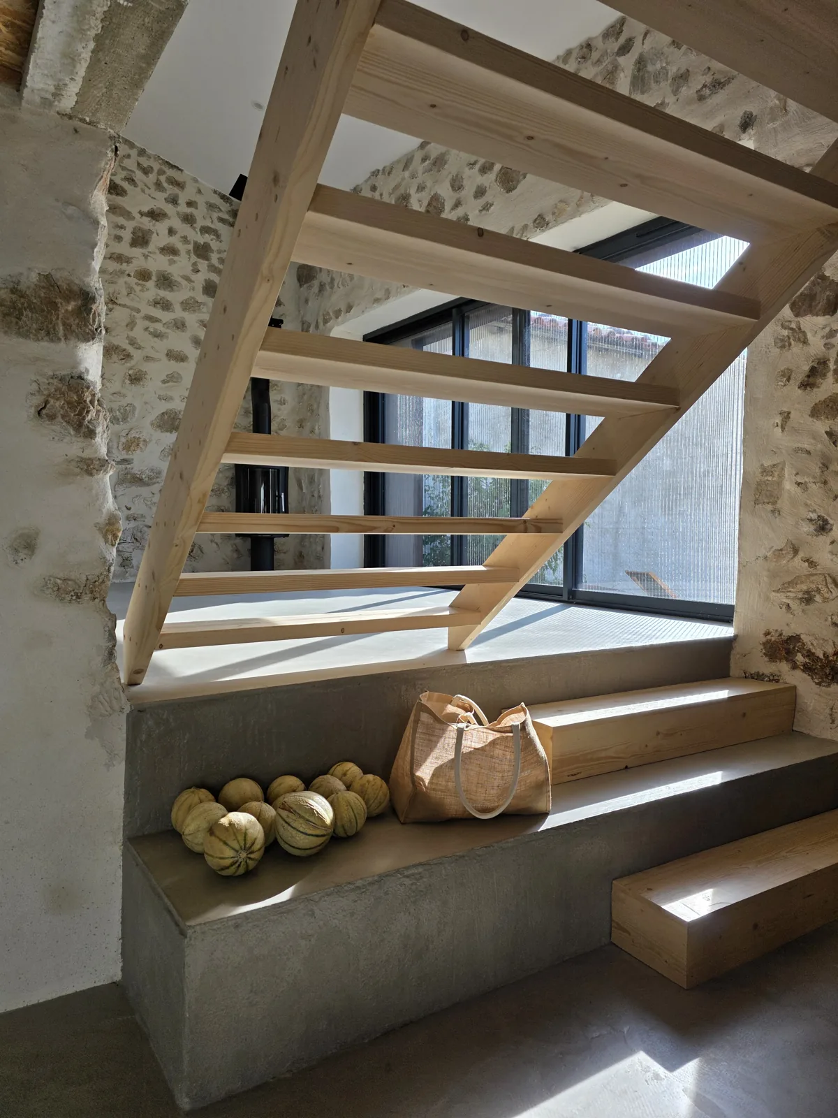 The staircase at Le Clat: timber treads in natural light