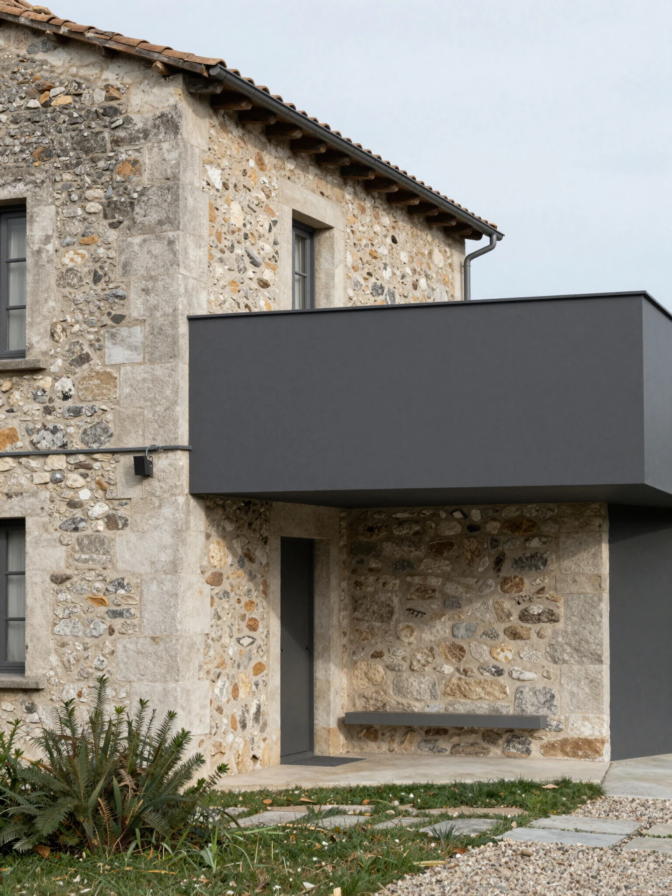 A projecting contemporary volume on a stone façade